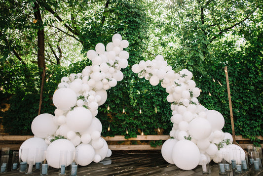 A stunning Balloon Arch made with White Latex Balloons placed outdoors